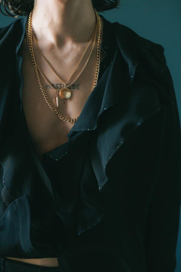 A Man Wearing Necklaces and a Black Top